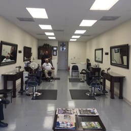 Here's the barber that does it all: working on an old timer while young man waits for his turn. Here's the barber that does it all: working on an old timer while young man waits for his turn.