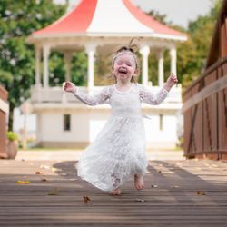 HZL Photography - Flower girl runs down the bridge towards the camera and she's having a great time! - Oshkosh Wedding Photography