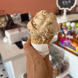 a hand holding a cone of ice cream