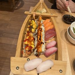 a wooden boat filled with sushi a wooden boat filled with sushi