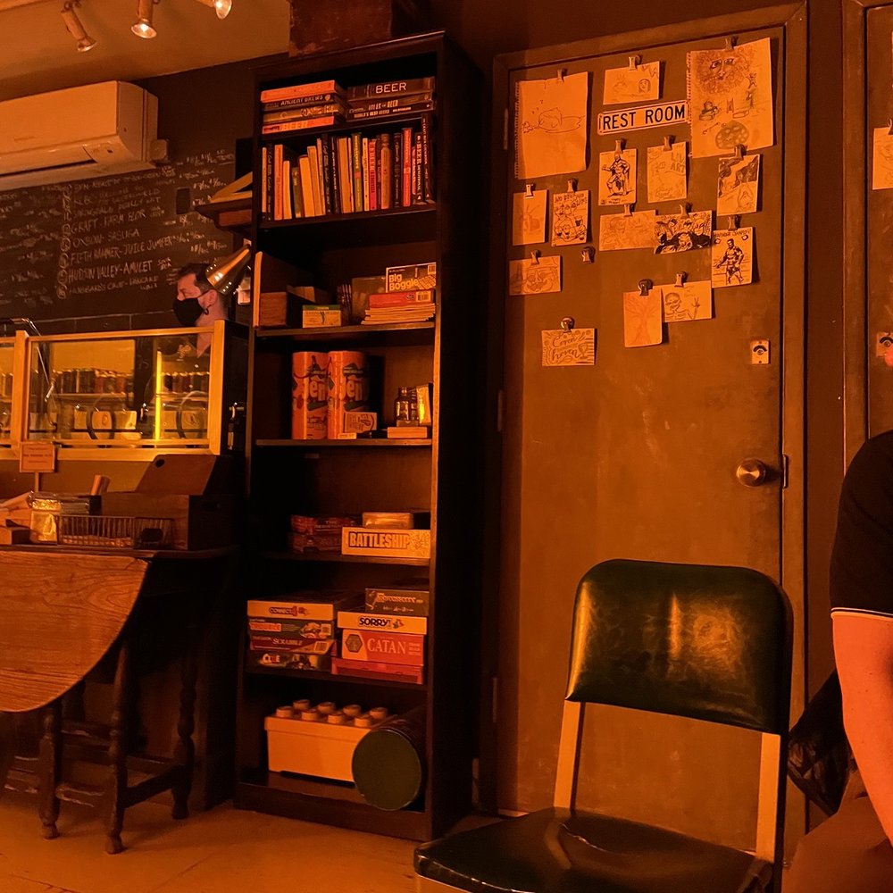 Covenhoven - a man sitting at a table in a coffee shop - Beer Bar Near Me - Brooklyn, New York