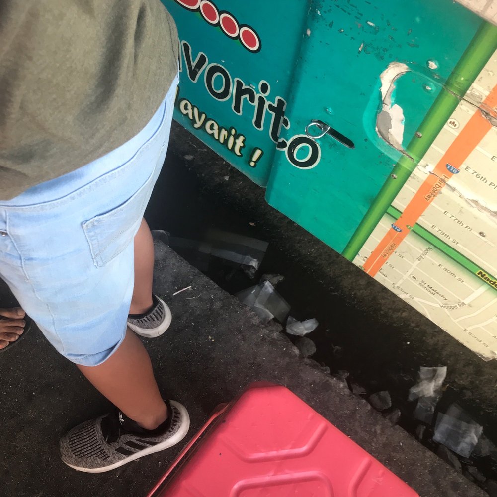 a woman standing next to a red suitcase