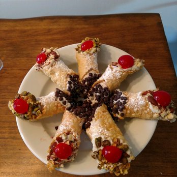 Cannoli by Vita - a plate of cannoli on a wooden table - Desserts Near Me