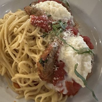 M’tucci’s Bar Roma - Eggplant parm ... with dry and possibly overcooked pasta - Spaghetti pasta topped with eggplant parmesan, tomato sauce, and grated cheese, served on a white plate. - Cocktail Bars Near Me - Albuquerque, New Mexico