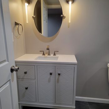 Sterling General Contractors - a bathroom with a sink, toilet, and mirror - General Contractors Near Me - Frederick, Maryland