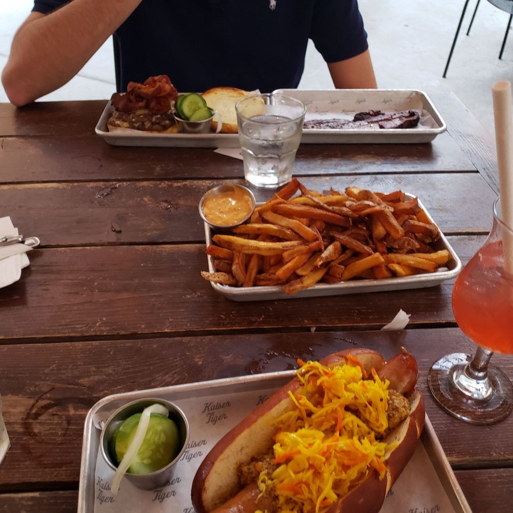 Kaiser Tiger - Tiki Time drink, cheesy brat, small fries with Cajun remoulade, Kaiser Royale, and housemade cracked pepper bacon - New American Near Me - Chicago, Illinois Kaiser Tiger - Tiki Time drink, cheesy brat, small fries with Cajun remoulade, Kaiser Royale, and housemade cracked pepper bacon - New American Near Me - Chicago, Illinois