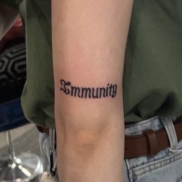 "Immunity" tattoo above elbow
