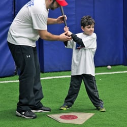 Unlimited Sports Action - Coach Rob helping a mini slugger with his batting stance