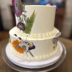 Wildflour - Vanilla on vanilla wedding cake decorated with dried pressed edible flowers