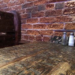 The Tav - The tables and brick wall are hand carved with the names of employees and patrons.