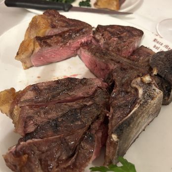 Buca Mario - Our T-Bone - Florentine Steak - sliced into serving sections by our waiter. - Tuscan Near Me - Florence, FI Buca Mario - Our T-Bone - Florentine Steak - sliced into serving sections by our waiter. - Tuscan Near Me - Florence, FI