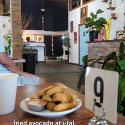 Fried avocado on wood grain table with partial interior view Fried avocado on wood grain table with partial interior view