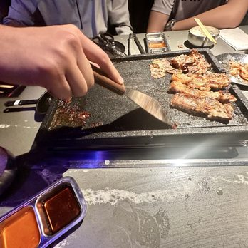 Champs Korean BBQ - Our Server cleaning our Cast Iron Griddle - Korean Near Me - San Diego, California Champs Korean BBQ - Our Server cleaning our Cast Iron Griddle - Korean Near Me - San Diego, California