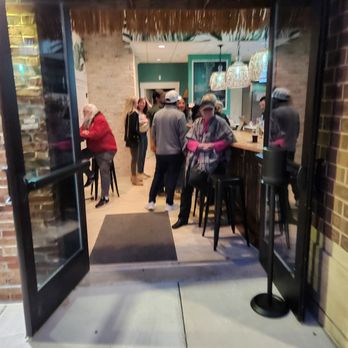 Sip Tiki Bar - a group of people sitting at a bar - Bars Near Me - Wilmington, North Carolina