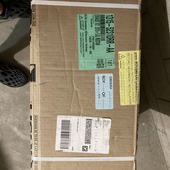 Vivid Racing - Vivid Racing sells parts manufactured in 2020 and does not disclose this. - A sealed cardboard box with multiple shipping labels and warning stickers, resting on a concrete surface. The box has white straps and various printed labels. - Auto Parts & Supplies Near Me - Gilbert, Arizona