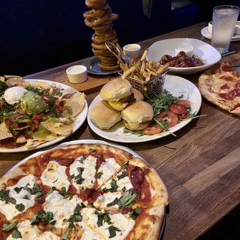 Yard House - Appetizers galore during happy hour! Onion Ring Tower** Chicken Nachos** Classic Sliders* ** Margherita** pizza - New American Near Me - Virginia Beach, Virginia Yard House - Appetizers galore during happy hour! Onion Ring Tower** Chicken Nachos** Classic Sliders* ** Margherita** pizza - New American Near Me - Virginia Beach, Virginia
