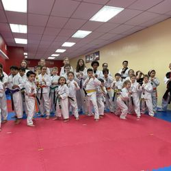Flying V Martial Arts - Instructor with all kids who got promoted to a new belt