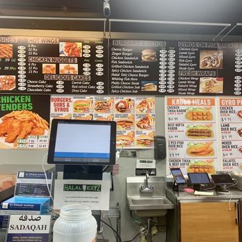 Halal Eatz - the menu of halal eatz - The photo captures the interior of a halal eatery featuring menu boards with options for burgers, gyros, and fried foods. The menu includes items like chicken nuggets, cheeseburgers, and lamb gyros. A digital checkout screen is positioned at the counter, with a card payment terminal nearby. The background shows a sink and some kitchen equipment, indicating a food service environment. The space is well-lit and organized for customer ordering. - Halal Near Me - Bethpage, New York