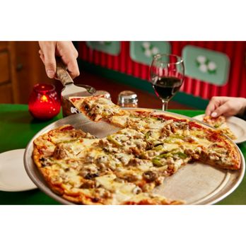 Oregano's - a person cutting a pizza - Pizza Near Me - Fort Collins, Colorado Oregano's - a person cutting a pizza - Pizza Near Me - Fort Collins, Colorado