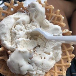 a hand holding a waffle with a spoon a hand holding a waffle with a spoon