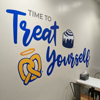 Cinnabon - a wall with a sign that says time to treat yourself - Bakeries Near Me - Dearborn, Michigan
