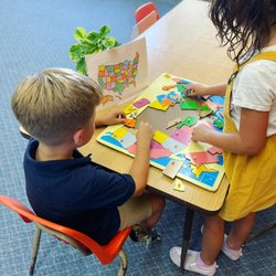 Montessori Harbor-Mesa School - Working on a puzzle of the United States