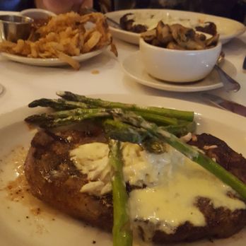 Harry & Izzy's - Ribeye with crabmeat and bearnaise, onion rings back left and mushrooms on the right - Steakhouses Near Me - Indianapolis, Indiana