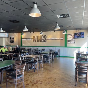 Wingstop - the inside of a restaurant with tables and chairs - Chicken Wings Near Me - Bessemer, Alabama