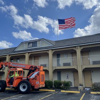 Texas Roof Guys - Loading shingles onto this hotel with a boom lift. - Roofing Near Me Texas Roof Guys - Loading shingles onto this hotel with a boom lift. - Roofing Near Me