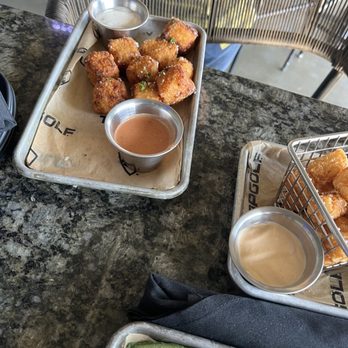 Topgolf - two trays of food on a table - Golf Near Me - Baton Rouge, Louisiana Topgolf - two trays of food on a table - Golf Near Me - Baton Rouge, Louisiana