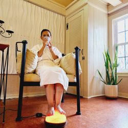 1 on 1 Self Indulgence - Client enjoys tea while warming her feet on a Himalayan Salt lamp