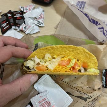 Del Taco - a hand holding a taco - Fast Food Near Me - Highland, California Del Taco - a hand holding a taco - Fast Food Near Me - Highland, California