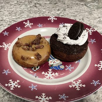 Maverick's Donuts - 2 donuts on a plate: Maple Bacon on the left and Oreo Nirvana on the right. - Donuts Near Me - Ottawa, Ontario Maverick's Donuts - 2 donuts on a plate: Maple Bacon on the left and Oreo Nirvana on the right. - Donuts Near Me - Ottawa, Ontario