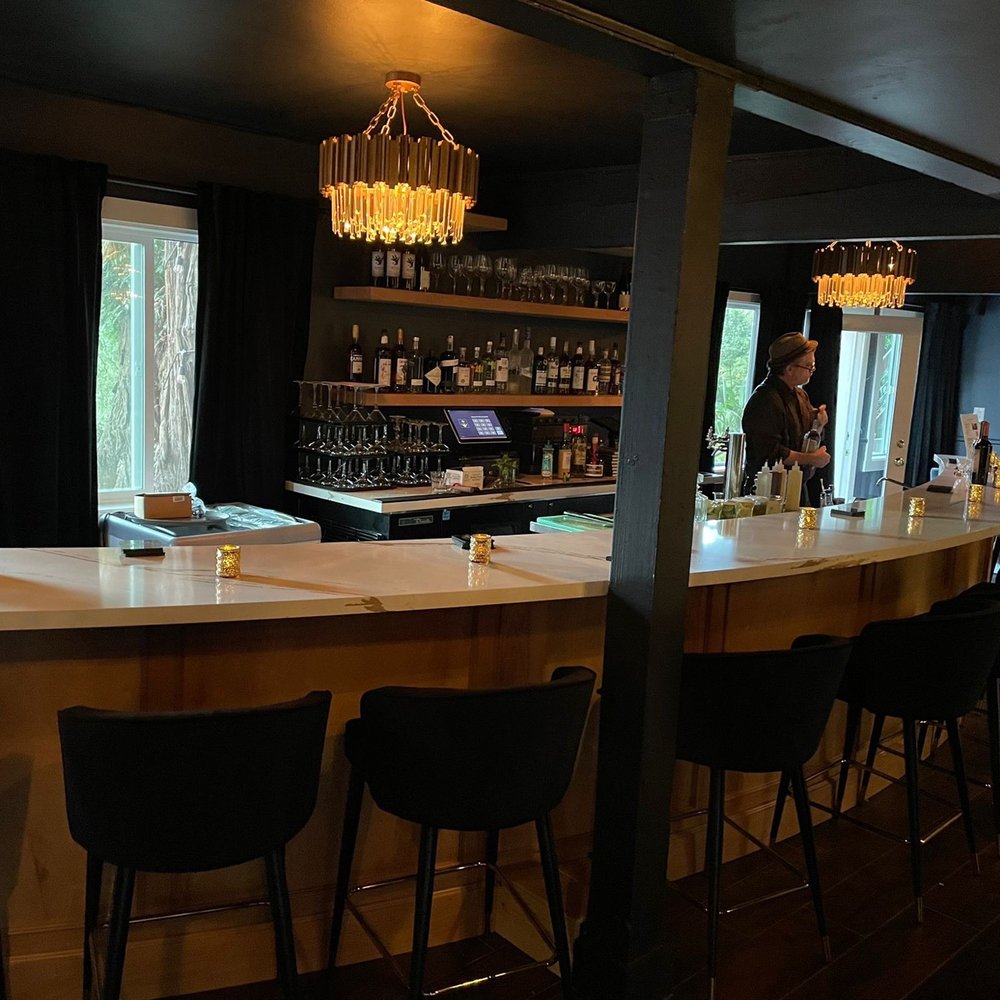 Boho Club - a bar with black chairs and a white counter - Speakeasies Near Me - Monte Rio, California Boho Club - a bar with black chairs and a white counter - Speakeasies Near Me - Monte Rio, California