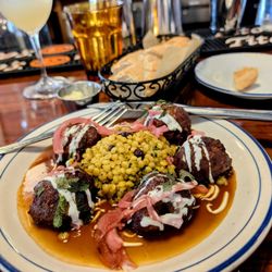 French Market - Lamb meatballs, Israeli cous-cous with dried currant, demi-glace, yogurt, fresh herbs, pickled red onion.  Bread and butter and a mocktail.