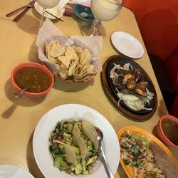 El Portal Mexican Grill - Mar y tierra fajitas steak with bacon wrap shrimp, chunky guacamole, chips and salsa, charro beans a frozen margarita and a piña colada.