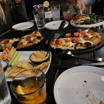 The Heights - a group of people eating pizza at a restaurant - Bars Near Me - Toledo, Ohio