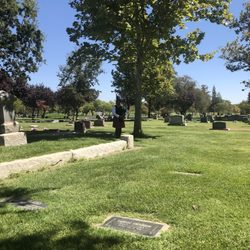 Davis Cemetery District & Arboretum - A photo of the burial with the bagpiper we were fortunate to have play at mom's burial. It was 105 degrees that day. Glad for the tree.