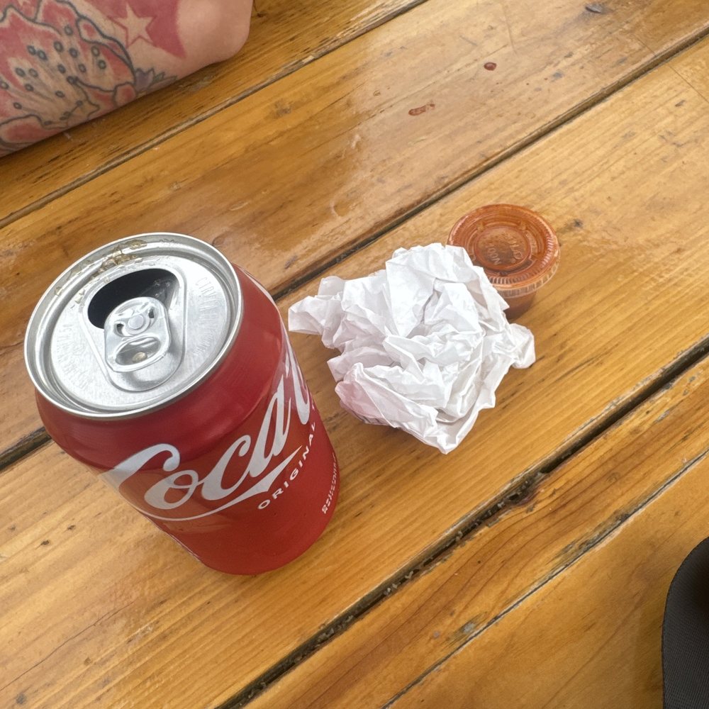 Empty wrapper from breakfast wrap and Tapatio hot sauce. The can of coke came from a vending machine at The Heist.