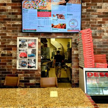 NAPOLI PIZZA - June 2021: The wall menu above the ordering/pickup counter. That's Owner Sam in the background - Pizza Near Me - TEMPLE TERR, Florida NAPOLI PIZZA - June 2021: The wall menu above the ordering/pickup counter. That's Owner Sam in the background - Pizza Near Me - TEMPLE TERR, Florida