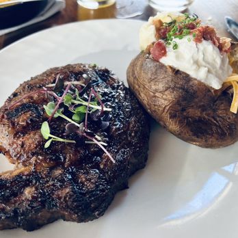 Walnut Kitchen - 14oz ribeye with potent peppery micro greens and loaded tater, paired with beer to make it greater 10/10 - Southern Near Me - Maryville, Tennessee