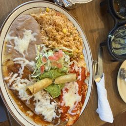 Great plate of food at a great price - A plate of Mexican food includes rice, enchiladas with cheese and sauce, and a small salad with lettuce, tomatoes, and a spring roll.