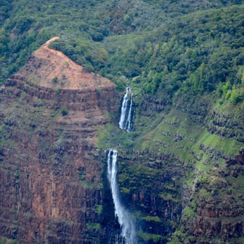 Waipo'o Falls - View of Waipo’o Falls from a helicopter. The trail comes out on the red earth to the left of the falls. It's wider than it looks. - Hiking Near Me - Waimea, Hawaii