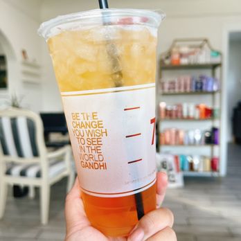 7 Leaves Cafe - a hand holding a cup of iced tea - Coffee & Tea Near Me - Tustin, California