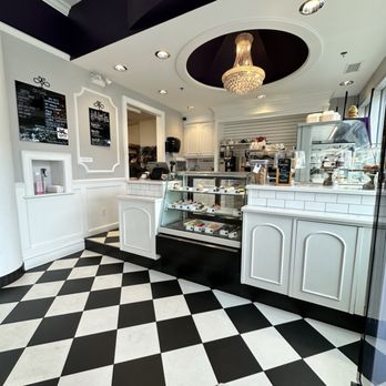 La Roux - black and white checkered floors, soft white paneling, and a chandelier that adds a touch of elegance above the counter - Bakeries Near Me - Victoria, British Columbia La Roux - black and white checkered floors, soft white paneling, and a chandelier that adds a touch of elegance above the counter - Bakeries Near Me - Victoria, British Columbia