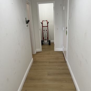 Amerifloors - an empty hallway with a red hand truck - Flooring Near Me Amerifloors - an empty hallway with a red hand truck - Flooring Near Me
