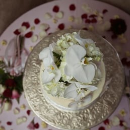 The cake topper, ribbons, and sprinkled flower petals adorning our cake were tasteful and exquisite. The cake topper, ribbons, and sprinkled flower petals adorning our cake were tasteful and exquisite.