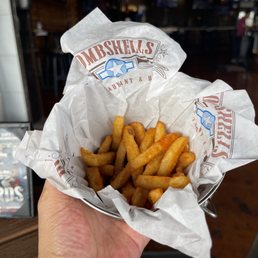 a hand holding a basket of fries a hand holding a basket of fries