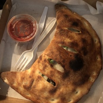 iSlice - This is the huge veggie calzone with its side of red sauce. - Pizza Near Me - Albany, California iSlice - This is the huge veggie calzone with its side of red sauce. - Pizza Near Me - Albany, California