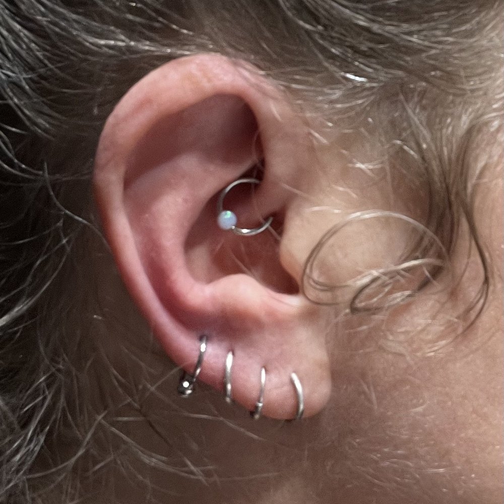 Phantom 8 Tattoo & Piercing - Stacie added the fourth love piercing and the daith piercing in this photo. - Tattoo Near Me - Englewood, Colorado